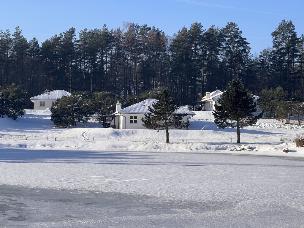 Zimowy widok na domki Ośrodka Wypoczynkowego JEZIORO nad jeziorem w Studzienicach.